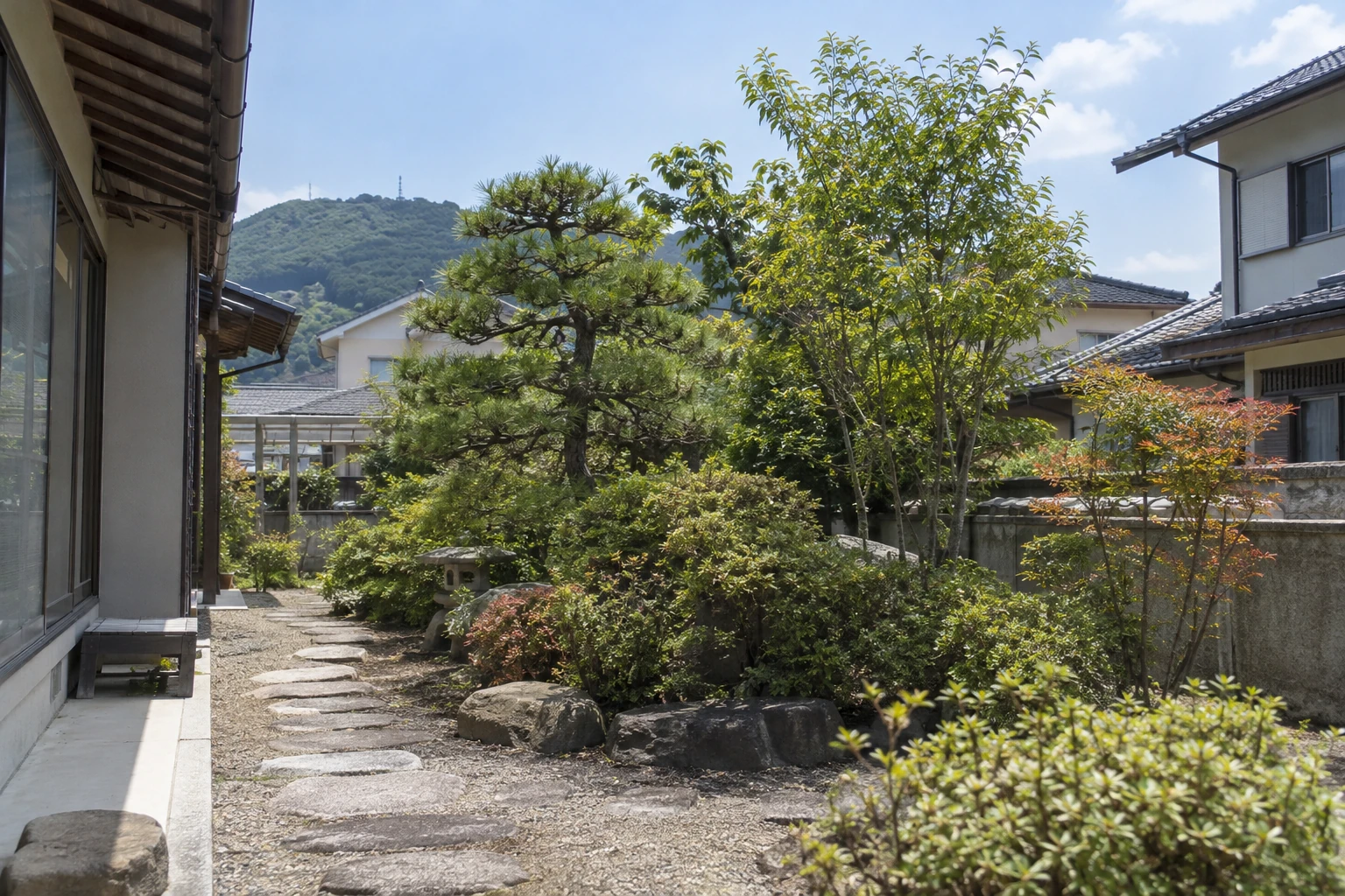 通路沿いの庭木と周囲の建物が見える庭