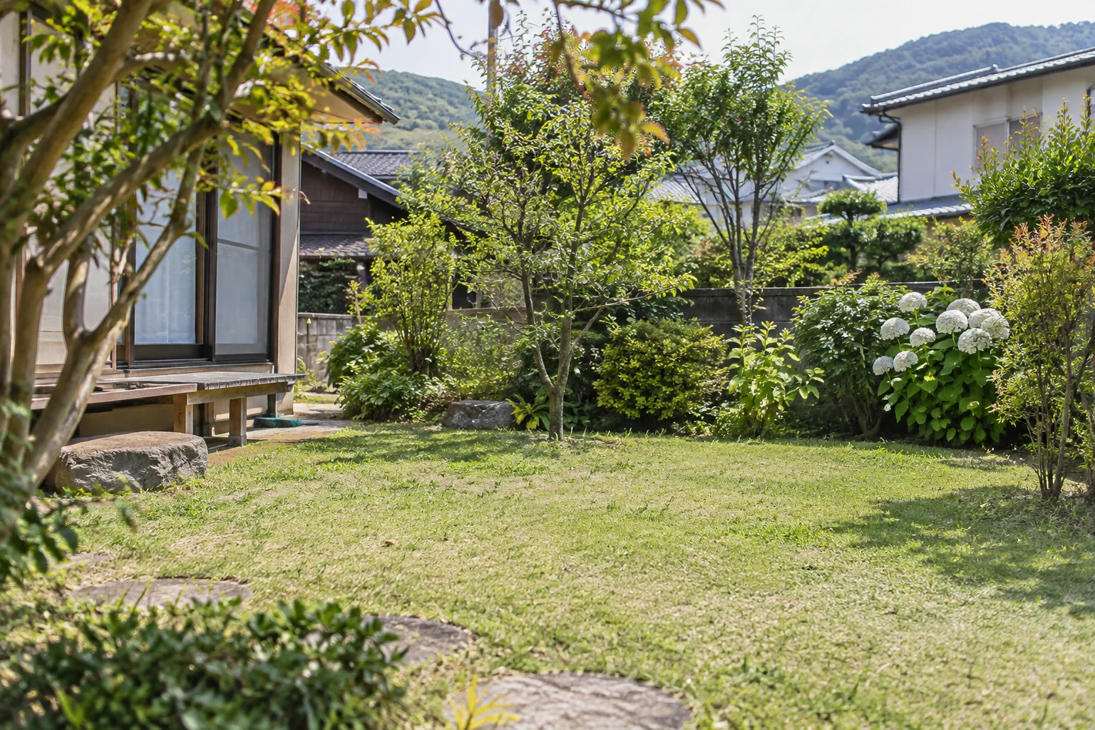 住宅のそばに庭木と草地がある庭