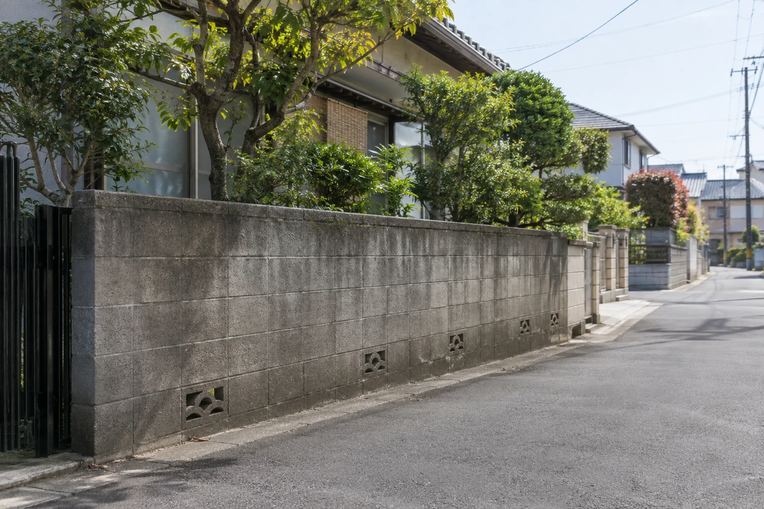 道路とブロック塀の位置関係を離れた場所から確認する様子
